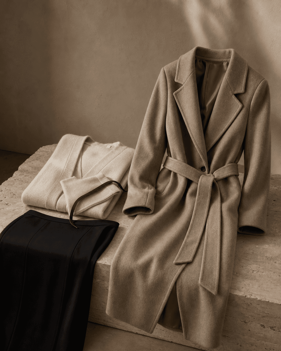 Camel longline coat styled with quiet knitwear